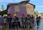 Bahu-Membahu,-Brimob-Pindahkan-Rumah-Terseret-Banjir-yang-Melintang-di-Jalan-Nasional-Tamiang–Langsa